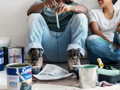 a couple sitting on the floor after housepainting