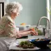 senior woman washing vegetables in the sink