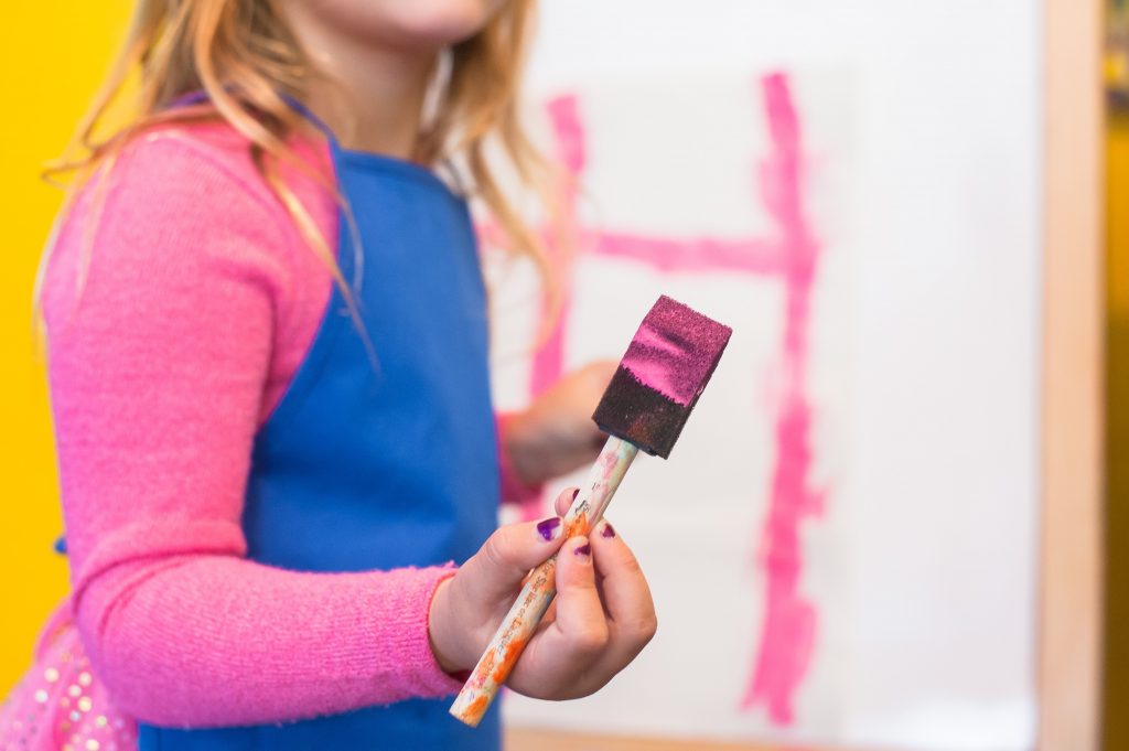 girl holding a paint brush
