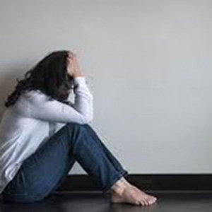 woman sitting on floor with her head in her hands