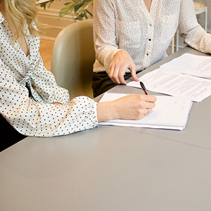 Two women sitting at a table reviewing documents