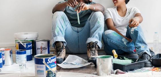 man and woman sitting with paint and brushes