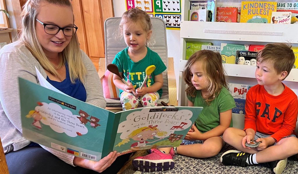 Children listening to a story read by an Early Childhood Educator