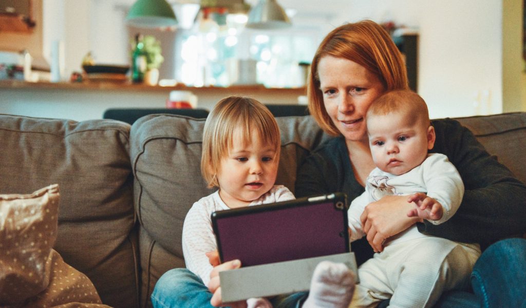 mother with two children on her lap looking at an ipad