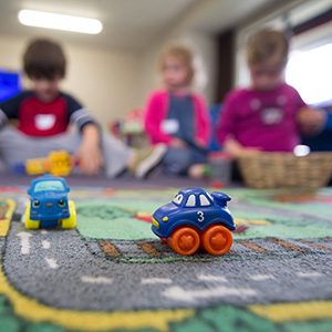 toy cars with children blurred out in the background