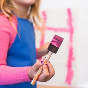 girl holding a paint brush