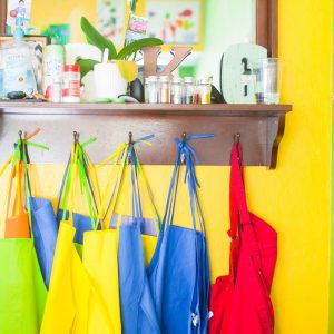 colourful painting aprons hanging on hooks